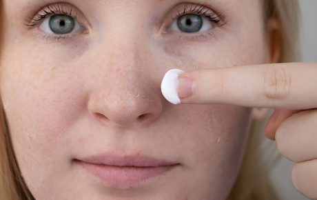Femeie aplica crema hidratanta pe ten cu piele uscata