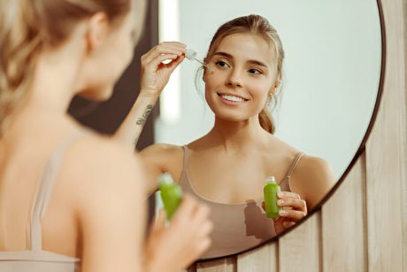 Femeie aplica serum hidratant pentru ingrijirea tenului uscat